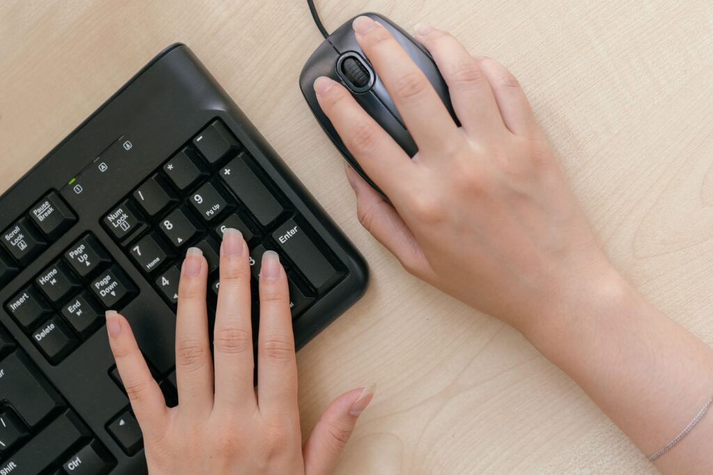 Close up of hands on keyboard and mouse